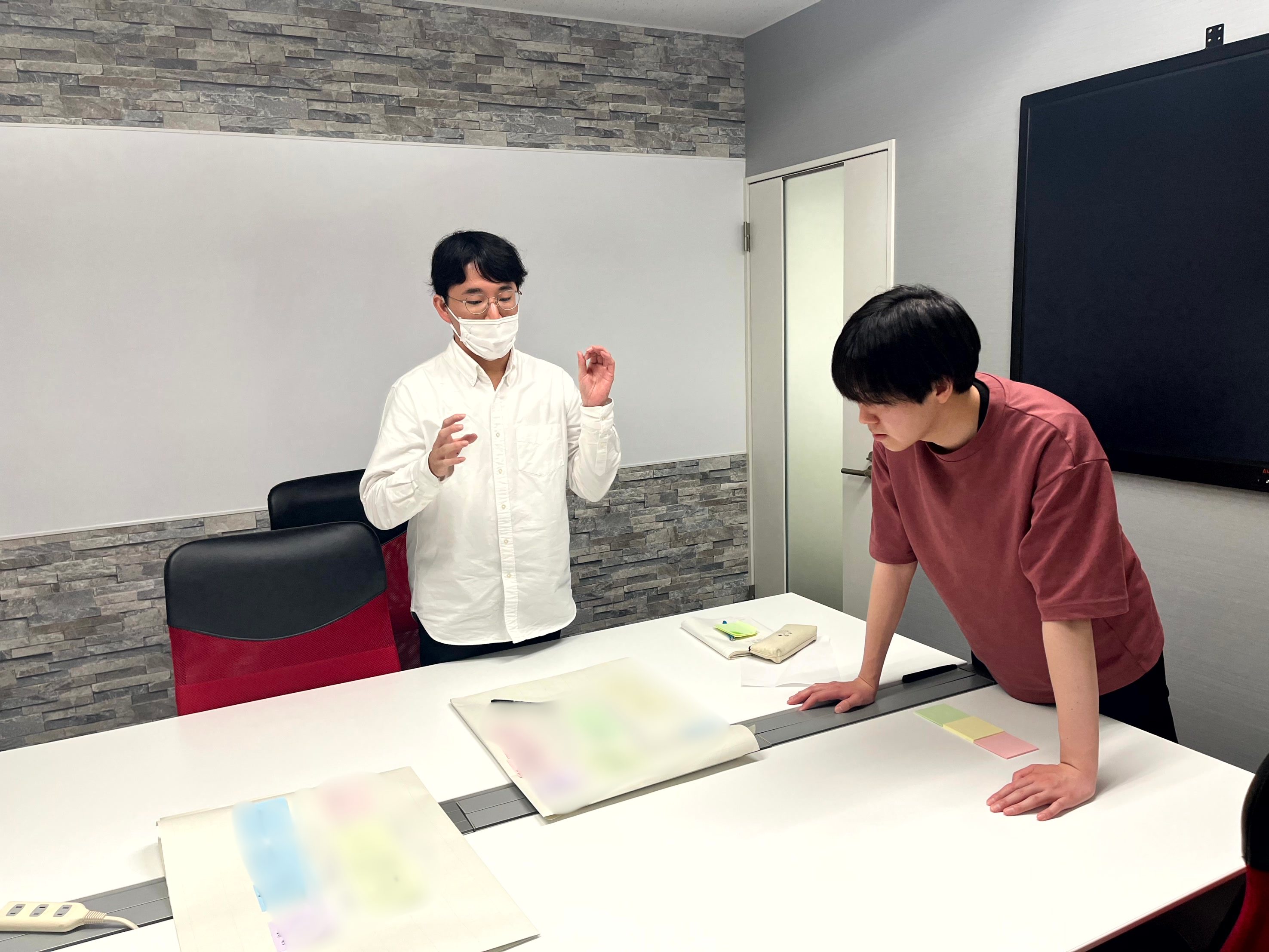 avinton-engineer-training-year3-pair-work 模造紙を使ってペアワークに取り組む入社3年目のエンジニアたち。組織視点やリーダーシップについて議論している様子。