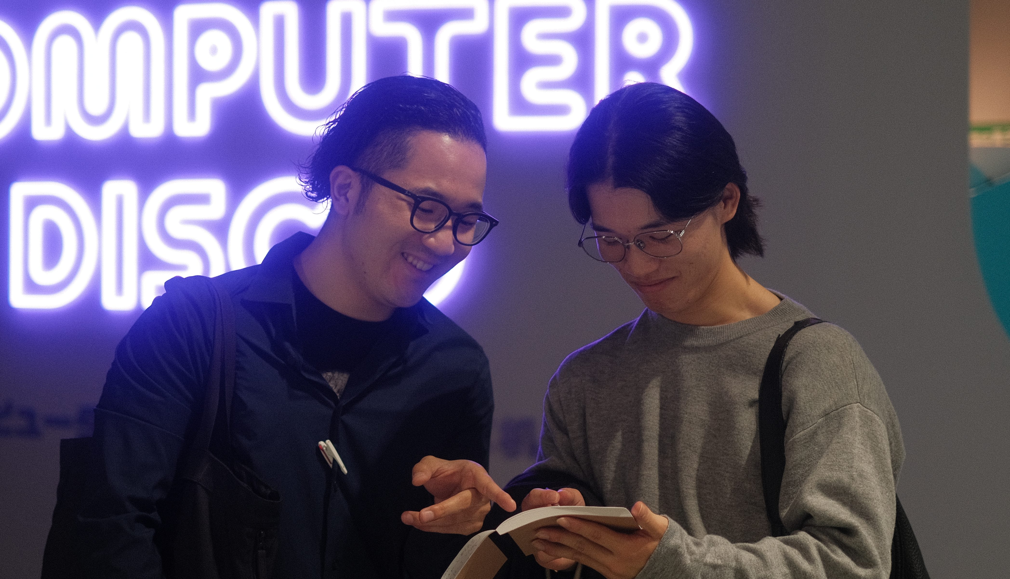 avinton-engineer-training-year4-fieldwork-discussion 日本科学未来館でのフィールドワーク中、笑顔で議論する4年目社員。