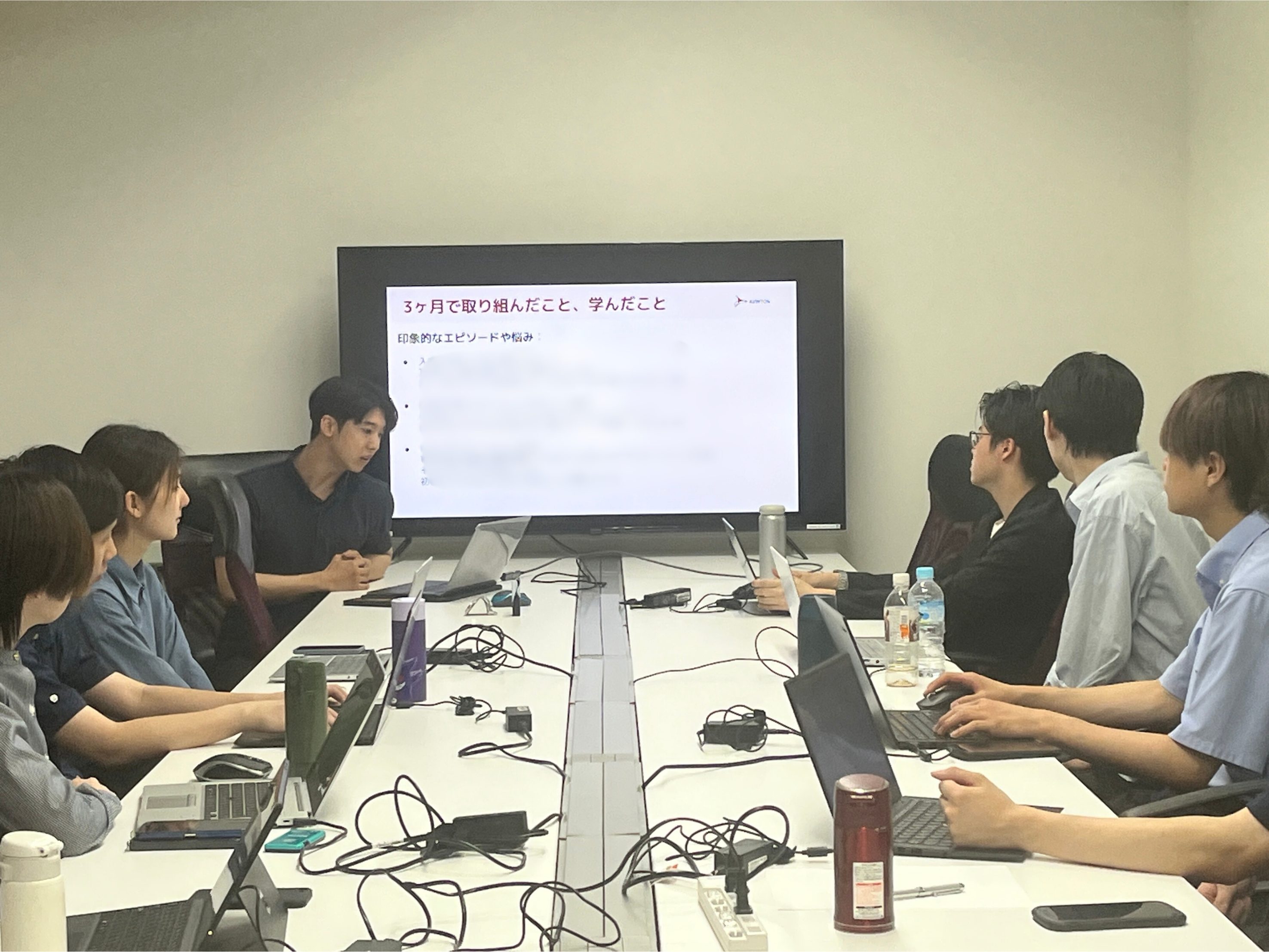avinton-new-grad-training-year1-presentation 研修の成果をモニターの前で発表する新卒社員。入社後3ヶ月間の成長を振り返り、今後の目標をアウトプットしています。