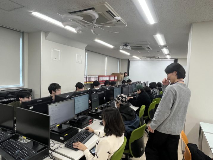 Pythonのハンズオン演習にて、学生からの質問に答えるため教室内を回り、サポートを行っているAvintonエンジニアの様子。