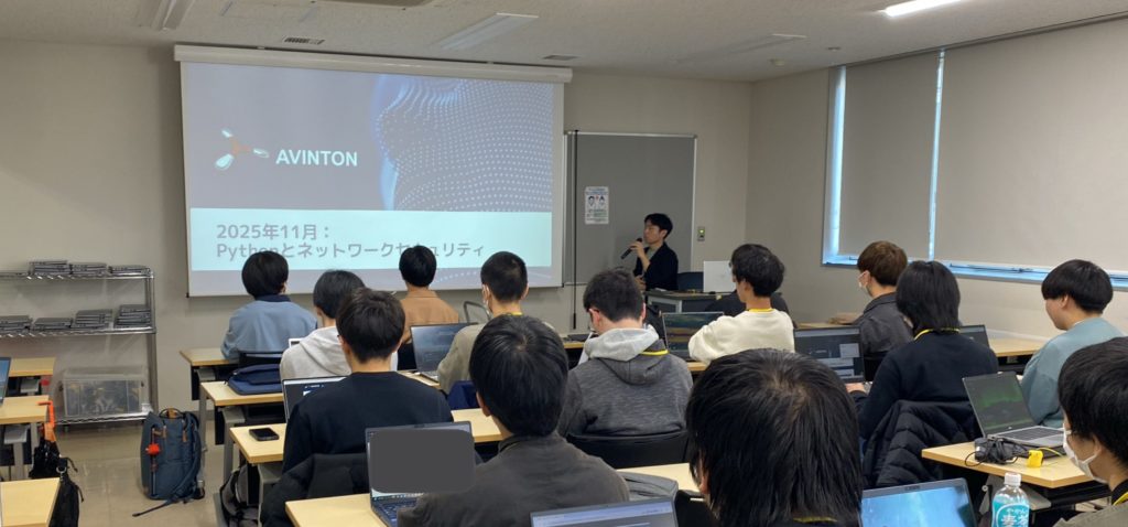 プロジェクター投影画面の前で、ネットワークセキュリティ科の学生にPythonの講義を行うAvintonエンジニアの様子