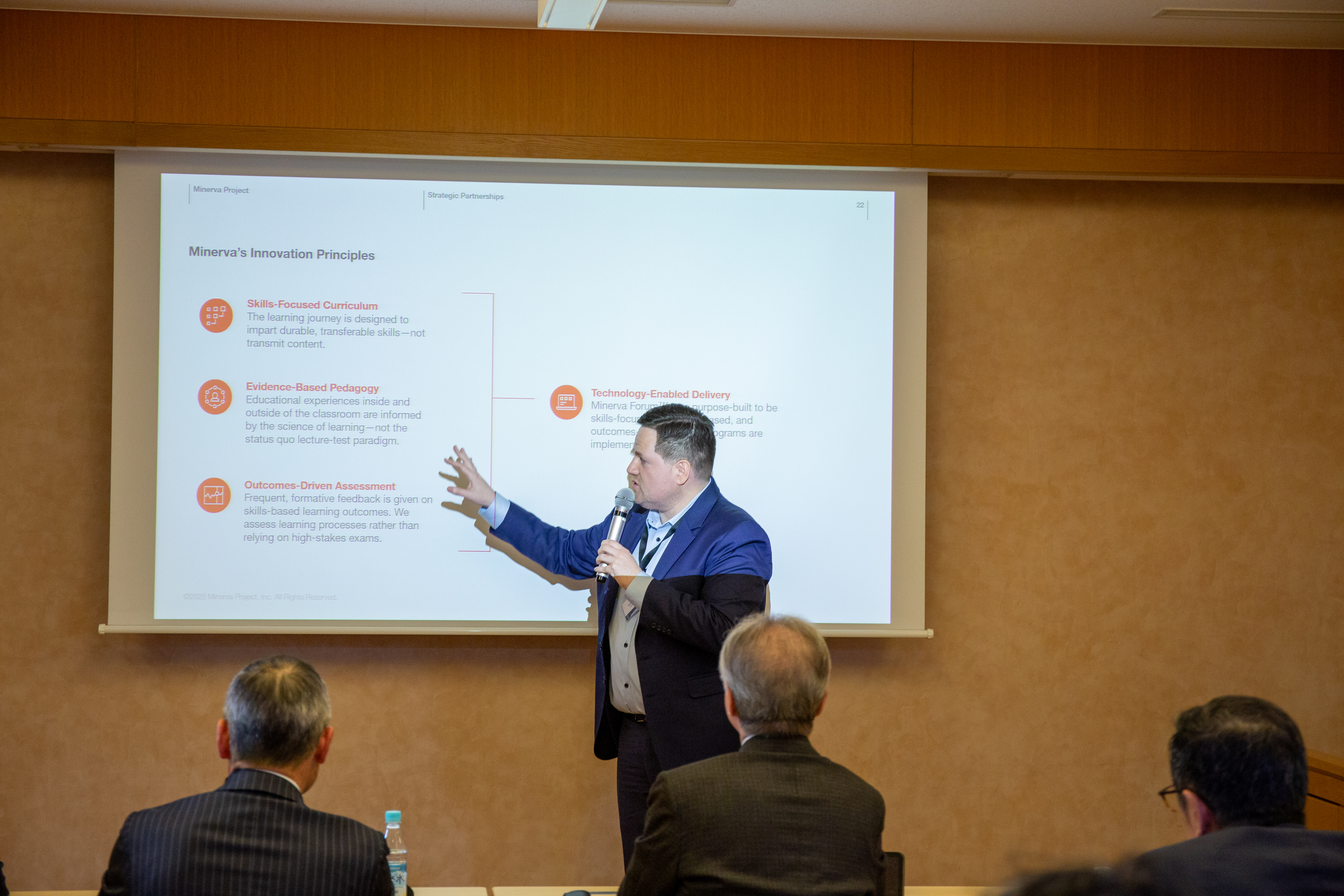 カリキュラム設計やエビデンスに基づく教育法など、スライドを用いて具体的な実践方法を提示する様子