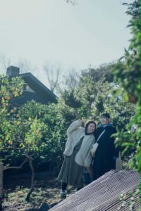 manazuru-sano-farm-citrus-orchard 真鶴町の佐野農園のみかん畑で、豊かな緑の木々に囲まれて笑顔で並ぶAvintonの中瀬さんと佐野農園の佐野杏さん。